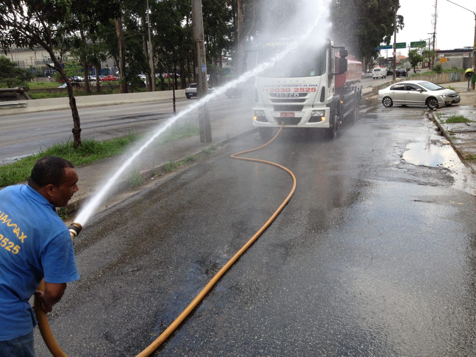 Equipe Aguamax operando a mangueira de um caminhão pipa durante abastecimento