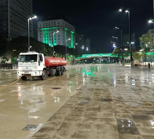 Caminhão Aguamax lavando praça pública no centro de São Paulo à noite